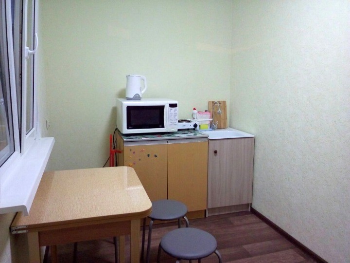 Отдельная кухня с раковиной, плитой, чайником и микроволновкой